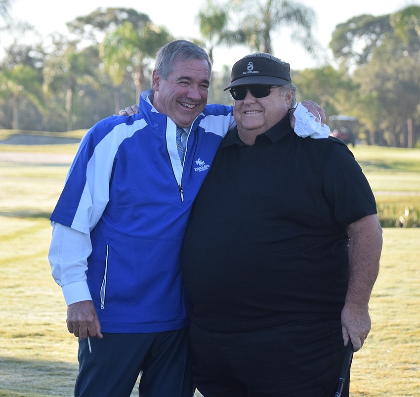 General Manager Joe Rassett and longtime resident Richard Stehle share a laugh after Stehle hit a commemorative shot off the first tee.