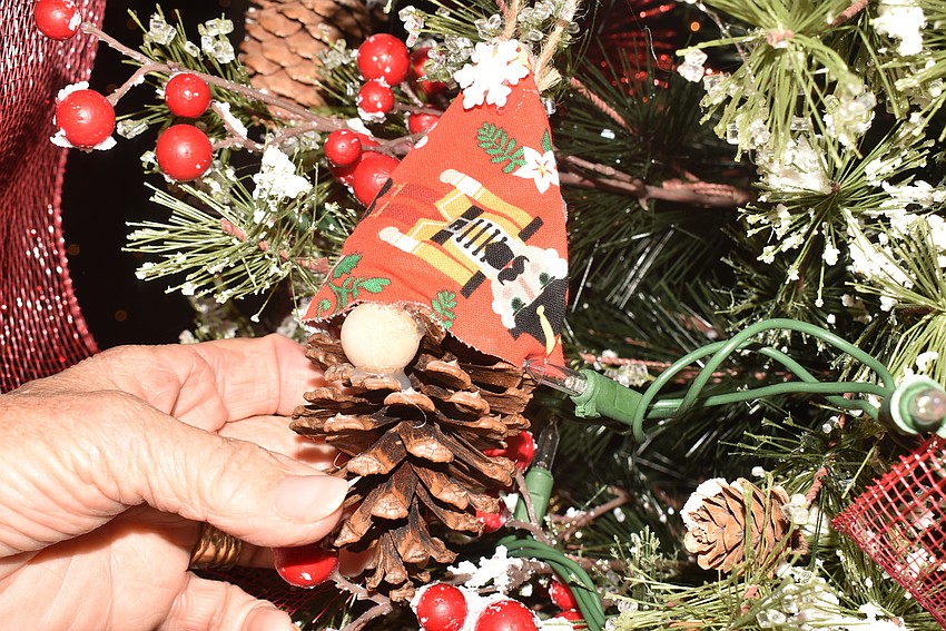 Lesley Rife holds up a gnome pinecone ornament.