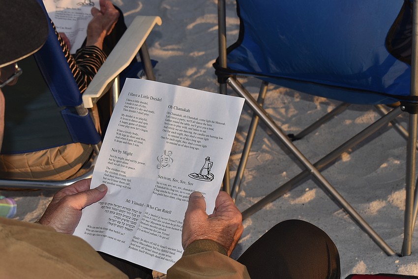 Sam Roth reads the handout of Hanukkah songs.