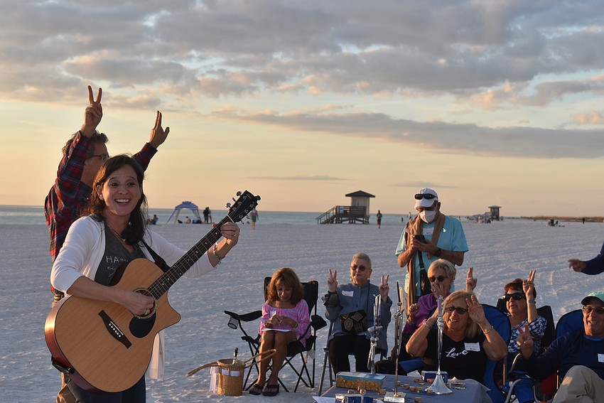 Barbara Mazer sings while Rabbi Brenner Glickman leads attendees in movements.