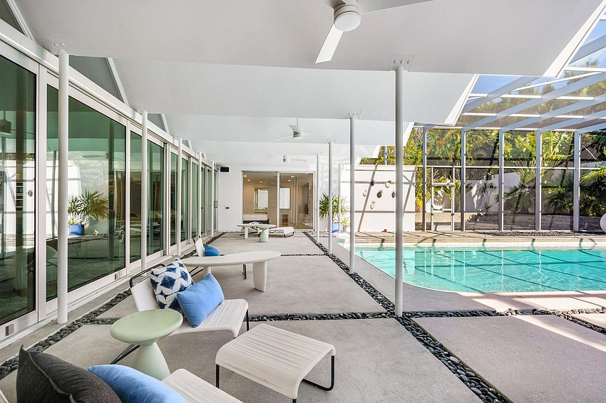 Floor to ceiling glass overlooks the pool area.