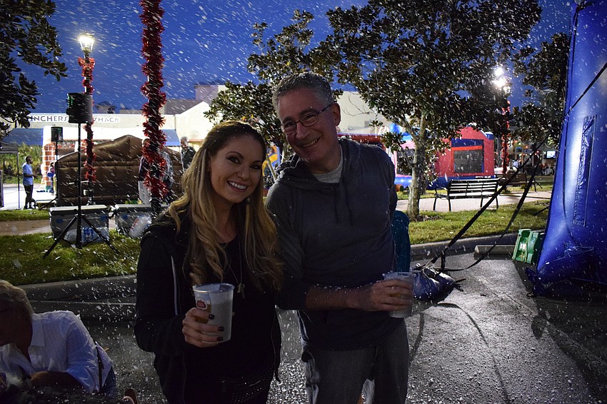 Nikki Milbrod of Orlando and her dad Steve Milbrod of Lakewood Ranch enjoy a snow storm during Music on Main. 