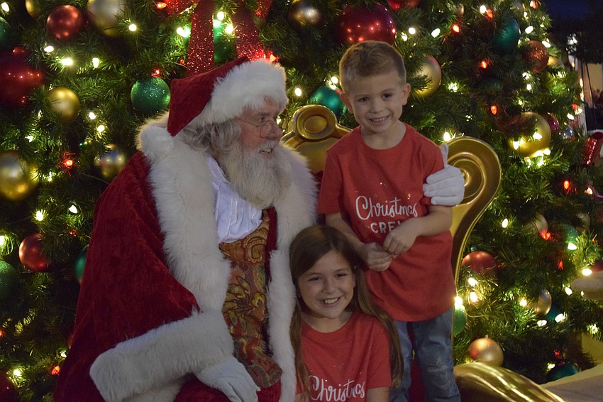 Santa gets the Christmas wish lists from Carolina Landings' Emma Alloy, 10, and Jacob Alloy, 5.