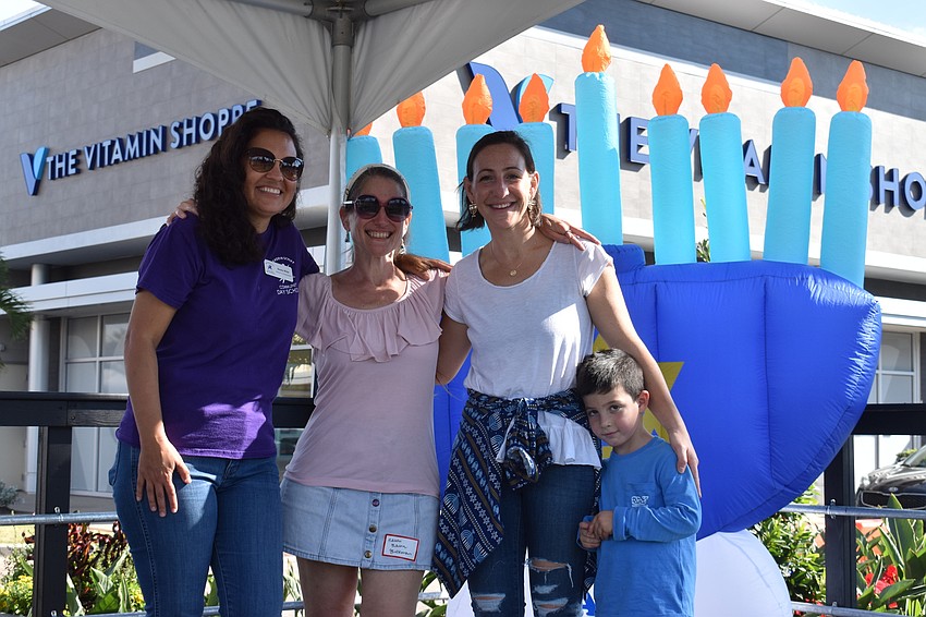 Brenna Wilhom, Rabbi Elaine Rose Glickman, Rachel Benderson and Jacob Benderson are recognized by the crowd in the closing moments of Hanukkah at the Green.