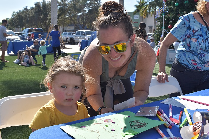 Ella Barwick and Carly Koelsch of Sarasota work at one of the crafts tables at Hanukkah at the Green.