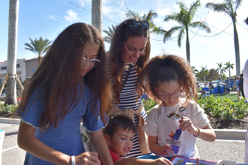 Lena, Leo, Maya and Ashley Lluberes, all of Lakewood Ranch, paint pieces that will eventually become a menorah.