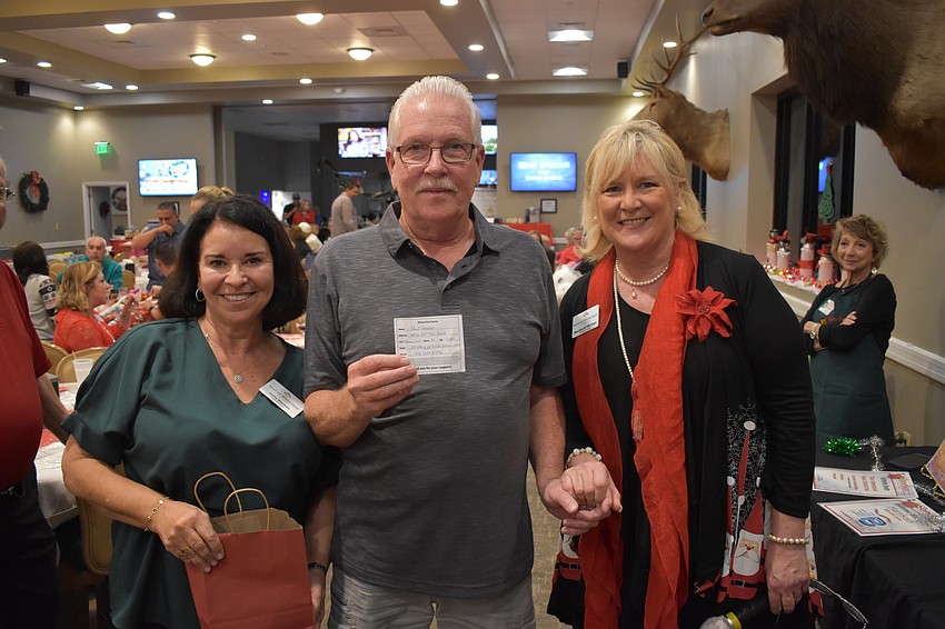 Kathy Martella (left) and Maribeth Phillips present Bradenton's Paul Reddy the winning ticket for the 50/50 raffle. Reddy immediately donated his $250 prize back to Meals on Wheels Plus Manatee.