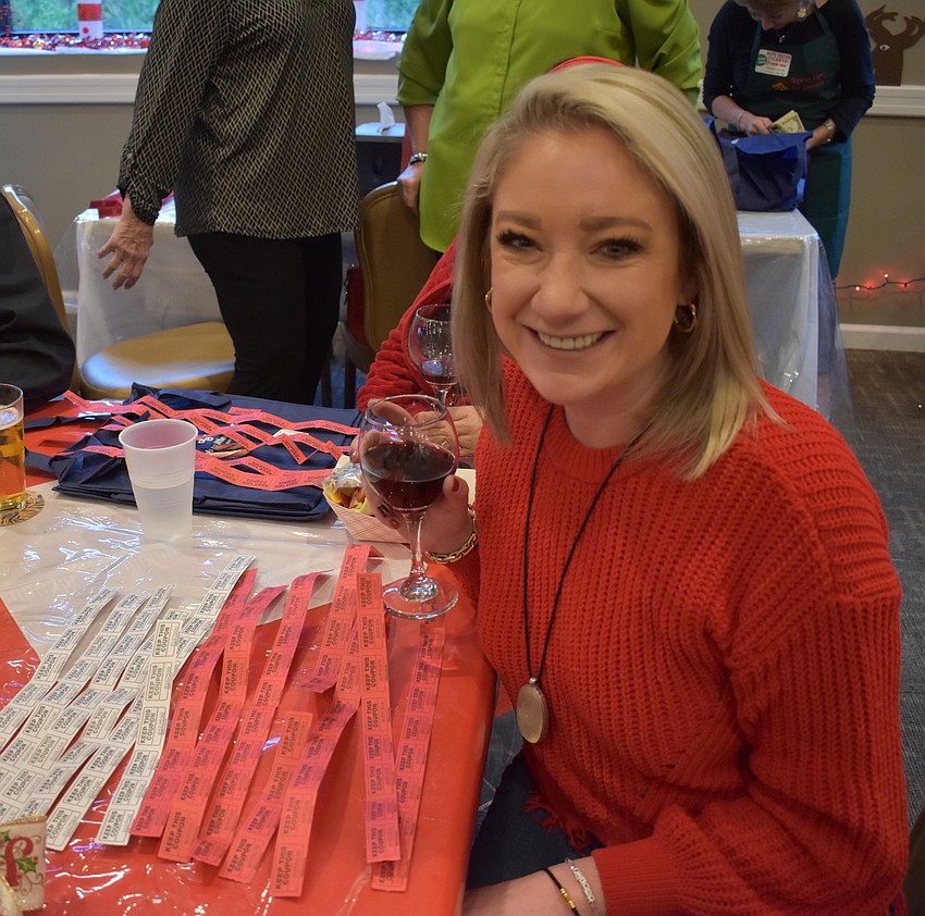 Julianne Niebour sits with a stack of raffle tickets at the reception. The large number of tickets paid off for her as she won a tablet and a lamp.
