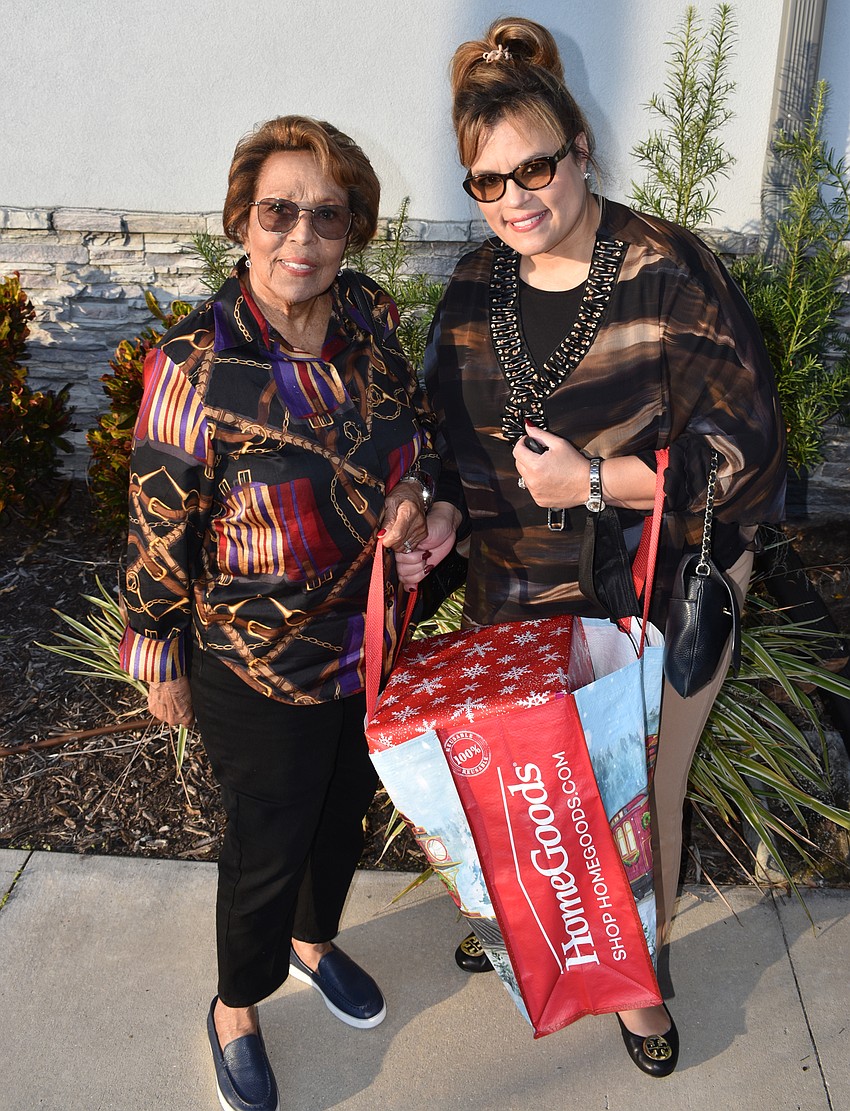 Margarita Cordova and Barbara Milian, both of Lakewood Ranch, arrive with a large bag of shoeboxes full of gifts for homebound seniors of Manatee County.