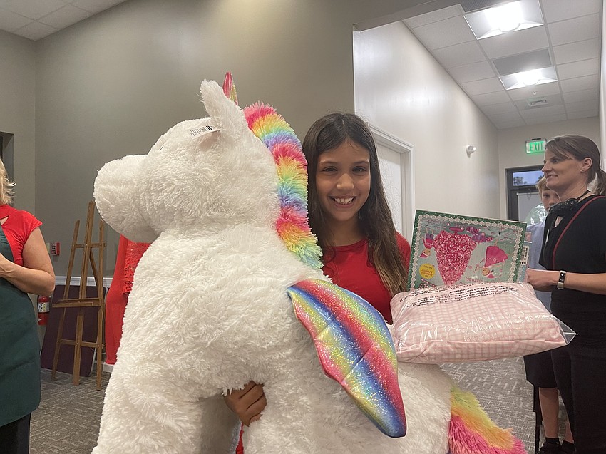 Lilly Gerling was all smiles after winning this giant stuffed unicorn in the raffle.