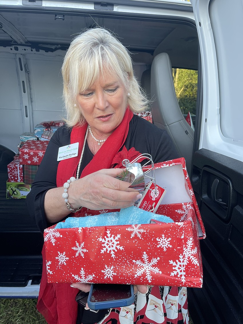 Meals on Wheels Plus Manatee President Maribeth Phillips shows off the contents of one of the donated shoeboxes that will be holiday gifts for seniors.