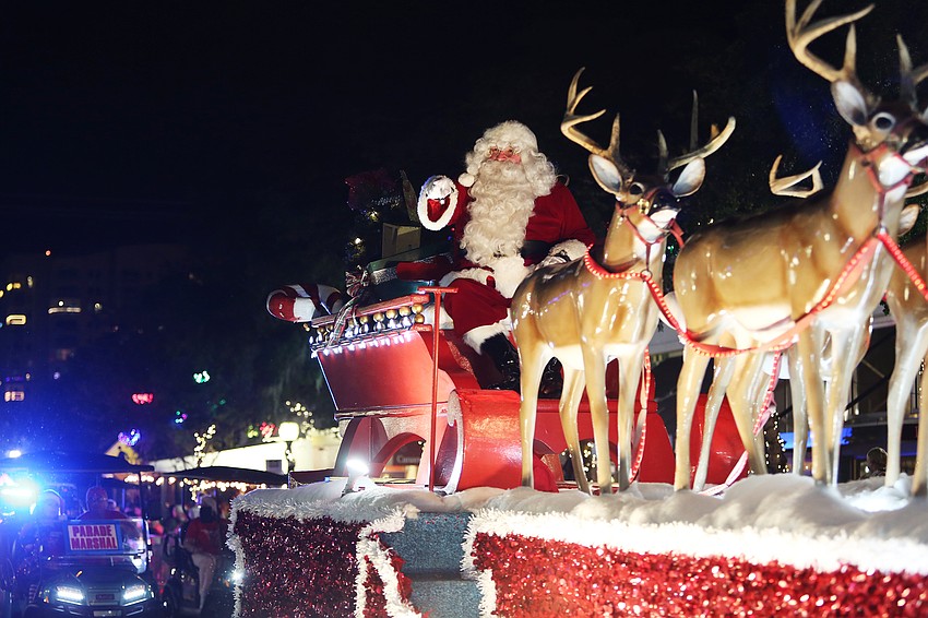 Santa Claus waves to cheering fans.