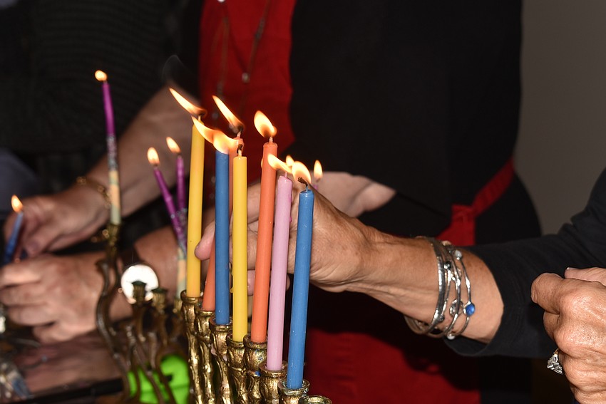 Barbara Diznoff lights her menorah.