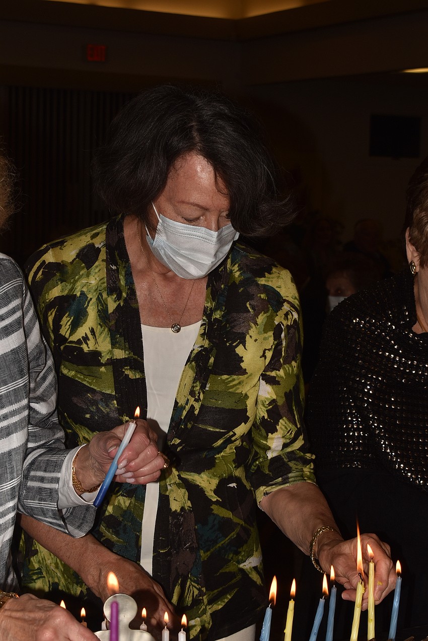 Karen Gary lights her menorah.