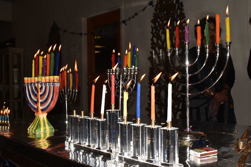 About a dozen menorahs lit up the front table at the temple.