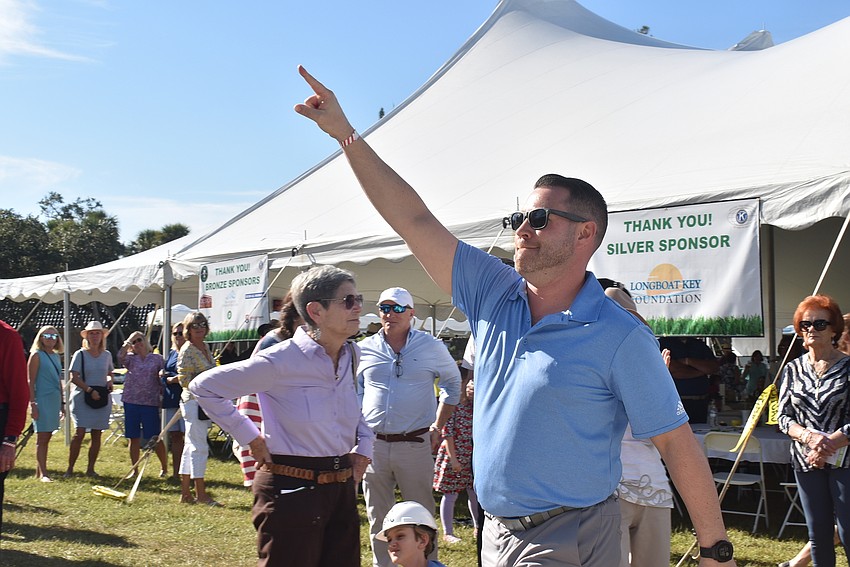 Adam Hughes celebrates after winning a year of dining on Longboat Key.