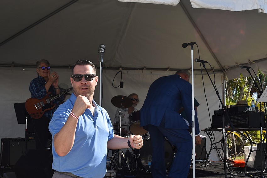 Adam Hughes celebrates after winning a year of dining on Longboat Key.