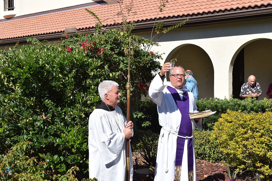 Acolyte Michael Downing stands next to the Rev. James Hedman, who gives a toast in honor of St. Mary Magdalene&#39;s 25th anniversary in Lakewood Ranch on Dec. 5.