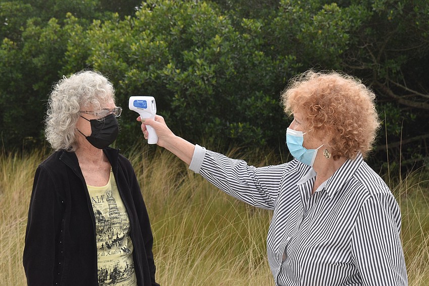 FEBRUARY: Gloria Feibus, right, checks Rise Loshack's temperature.