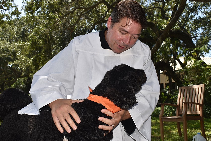 OCTOBER: Father Dave Marshall holds Reba for her blessing.