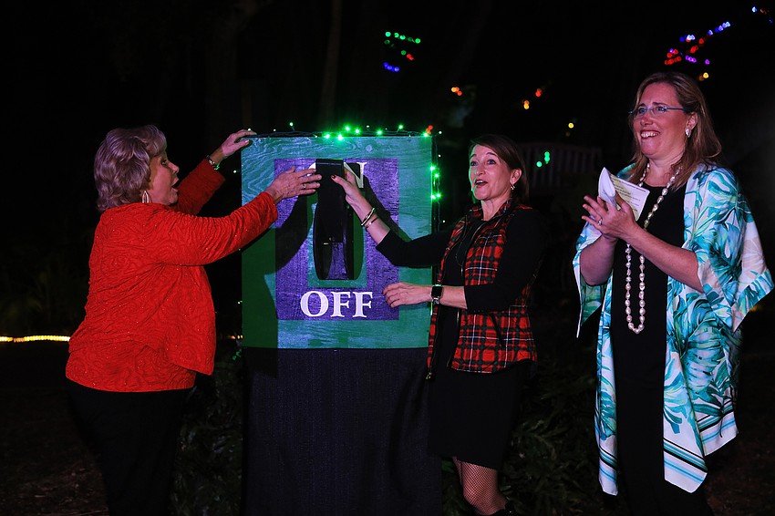 Linda Carson, Kirsten Russell and Jennifer Rominiecki flip the switch.