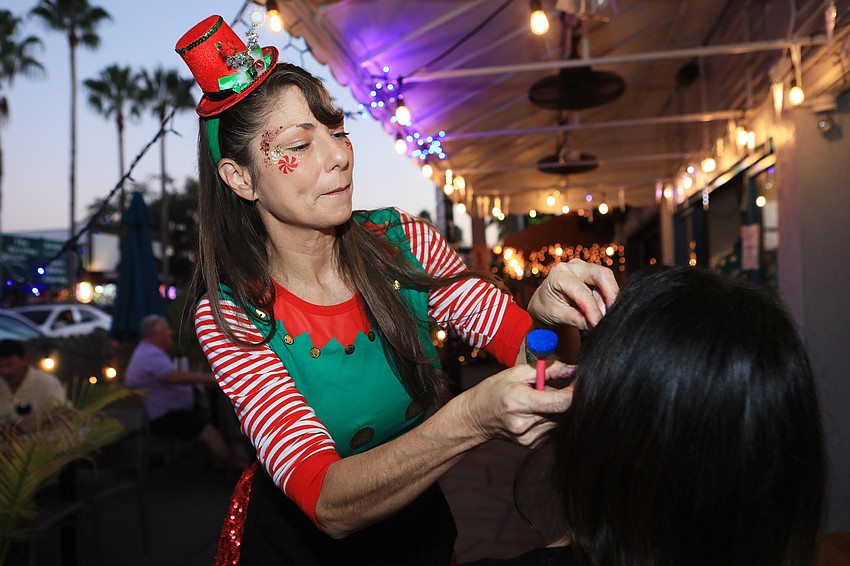 Susie Kalin does face painting for visitors.