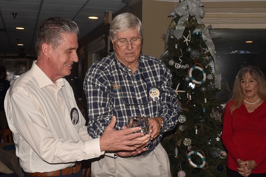 Michael Garey accepts a crystal statue from Bob Gault.