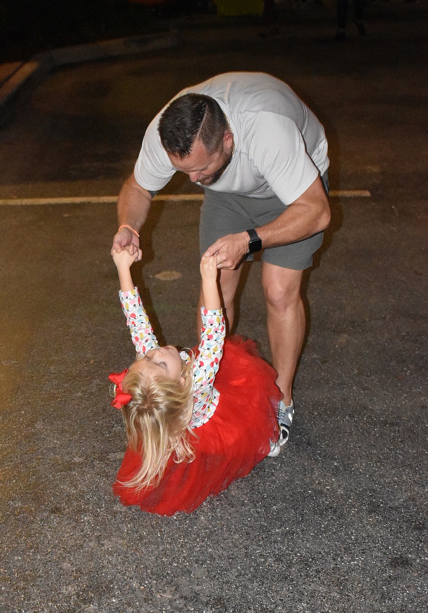 Kyle Barona of Lakewood Ranch dances with daughter Lumen to the music of Triggerfish.