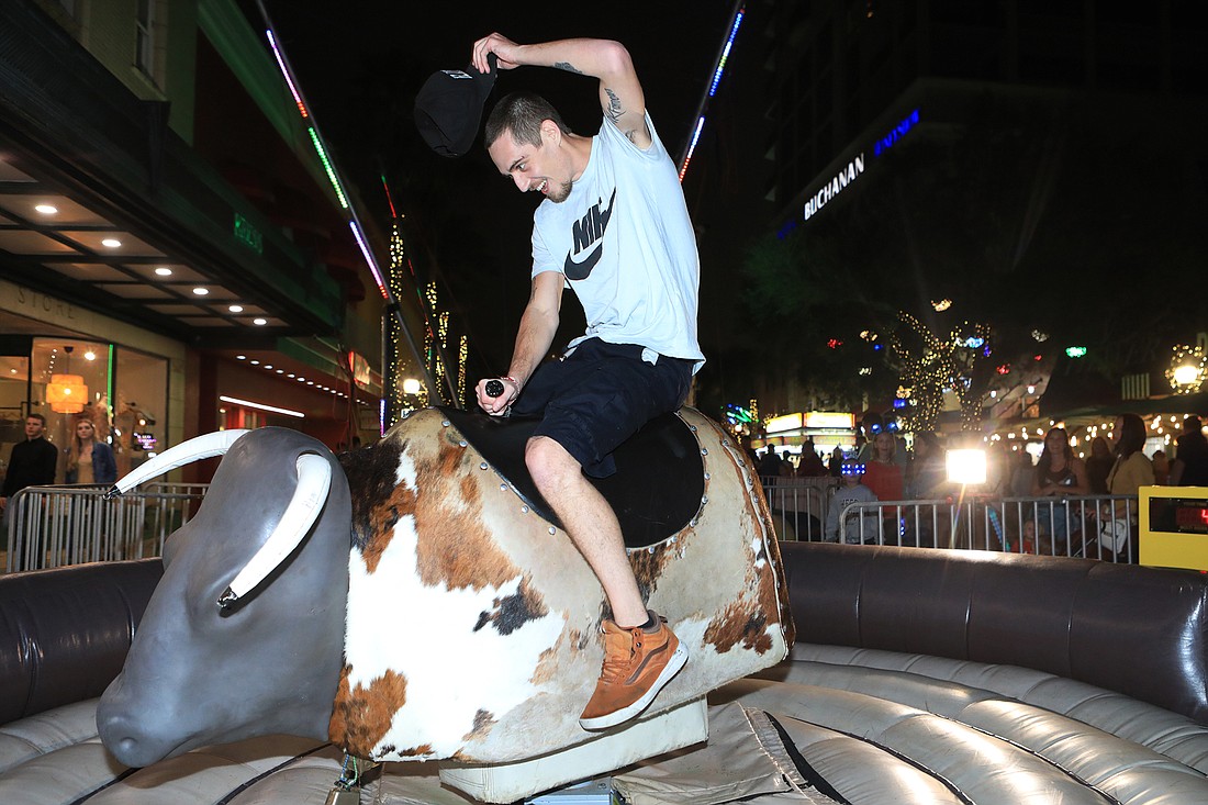 Bryan Dudnick rides the mechanical bull at the New Year's Eve Pineapple Drop on Dec. 31, 2021.