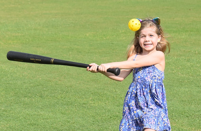 Ella Lane, an East County 6-year-old, gets in a little batting practice before the polo match.