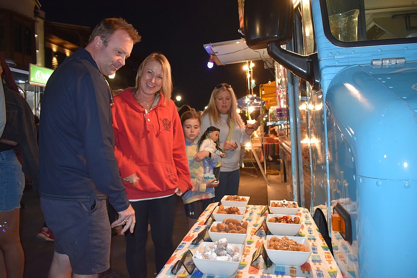 Lakewood Ranch's Mark Ford and Jane Ebury look over the selection of mini donuts from the Siesta Pops Mini Donuts food truck.