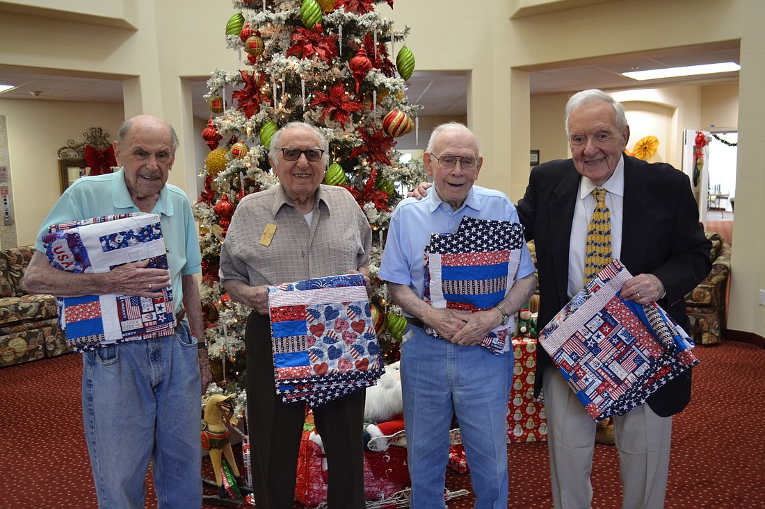 Ed Willett, Chip Tominelli, Charles Simmons and Joe Barbera, who are all veterans living at Cypress Springs Gracious Retirement Living, show off their new quilts. Courtesy photo.