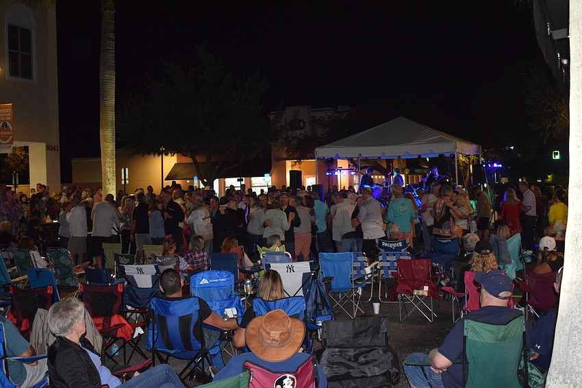 People sit in lawn chairs and dance as the Derek Lersch band performs on Main Street at Lakewood Ranch.