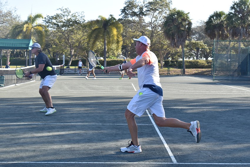 Dave Barcomb swings for a point in a doubles match.