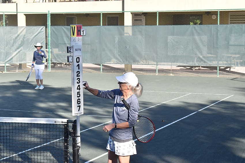 Peggy Lavallee adjusts the scoreboard.