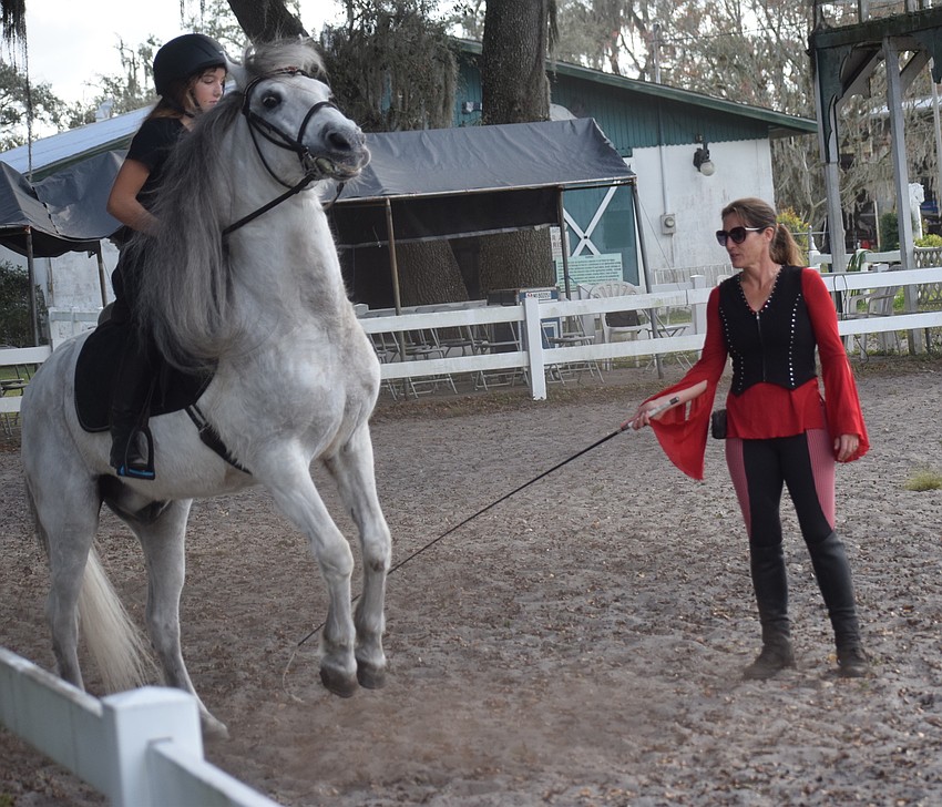 Sydney McCullough, 13, has started learning more difficult maneuvers with stallions such as Achilles. Her mom, Rebecca, supervises.