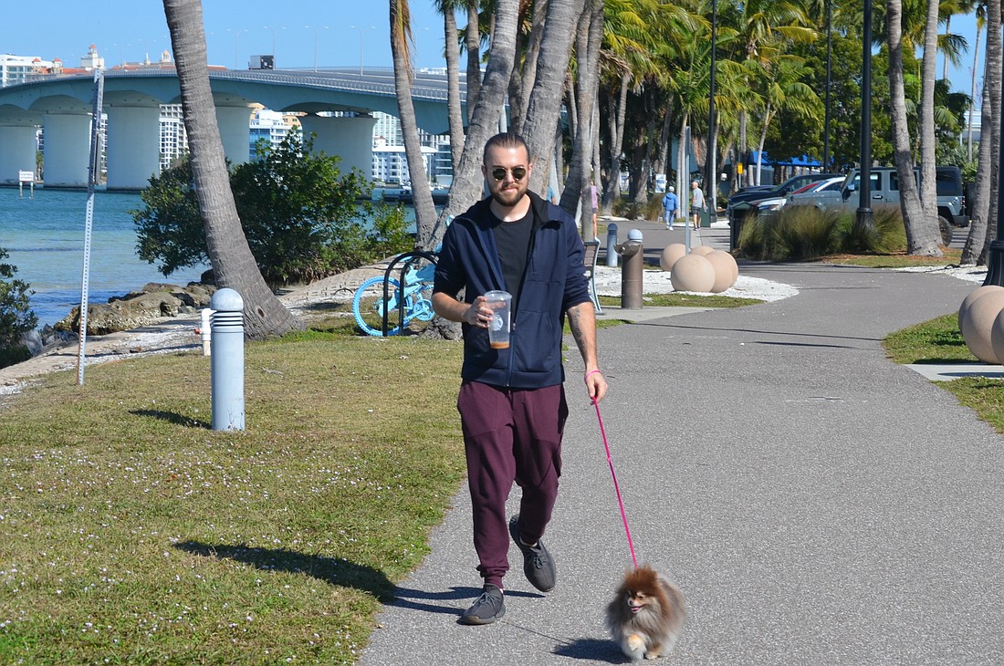 Max Taylor walking his dog, Miga, through Bird Key Park on Friday.