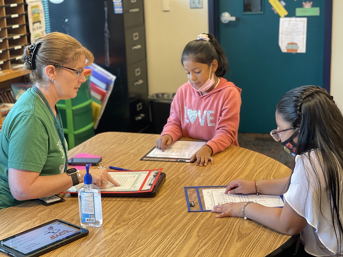 Maureen Geary, a third grade teacher at Myakka City Elementary School, teachers a vocabulary lesson to Katherine Millan-Pureco and America Carranza-Vazquez. Schools have changed COVID-19 protocols. Courtesy photo.
