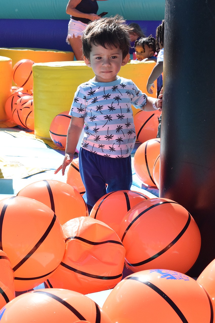 Sarasota's Emmanuel Alvez, who is 2 years old, makes his way through dozens of inflatable basketballs.