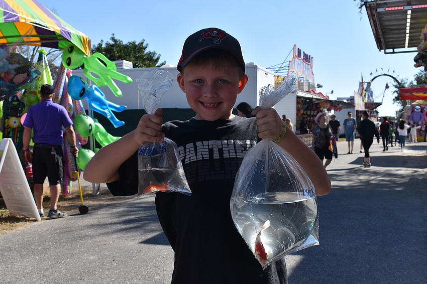 Conner Christman of Palmetto shows off the goldfish that he won by tossing ping pong balls into a jar.