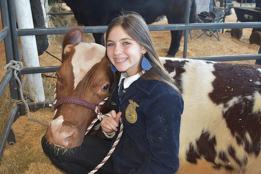 Camryn Shear of the  Carlos E. Haile Middle School FFA hugs her cow Trooper who took first place in Class 6.