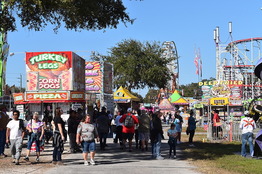 Revelers enjoy a walk through the midway on a picturesque Saturday at the Manatee County Fair.