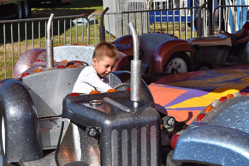 Christian Benzon, 3, of Bradenton, steers his semi truck on a ride in the midway.