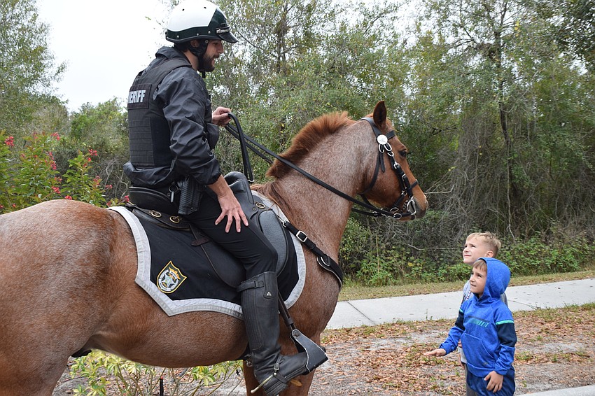 Zachary Bradley, a deputy with the Manatee County Sheriff's Office, lets 7-year-old Preston Frost and 5-year-old Nolan Frost get a good look at his horse. The boys live in Greenbrook.