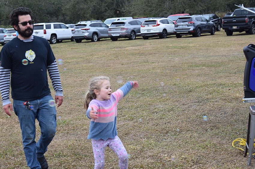 Greenbrook 5-year-old Kestra Bencomo plays in a stream of bubbles under the watchful eye of her dad, Zach Bencomo.