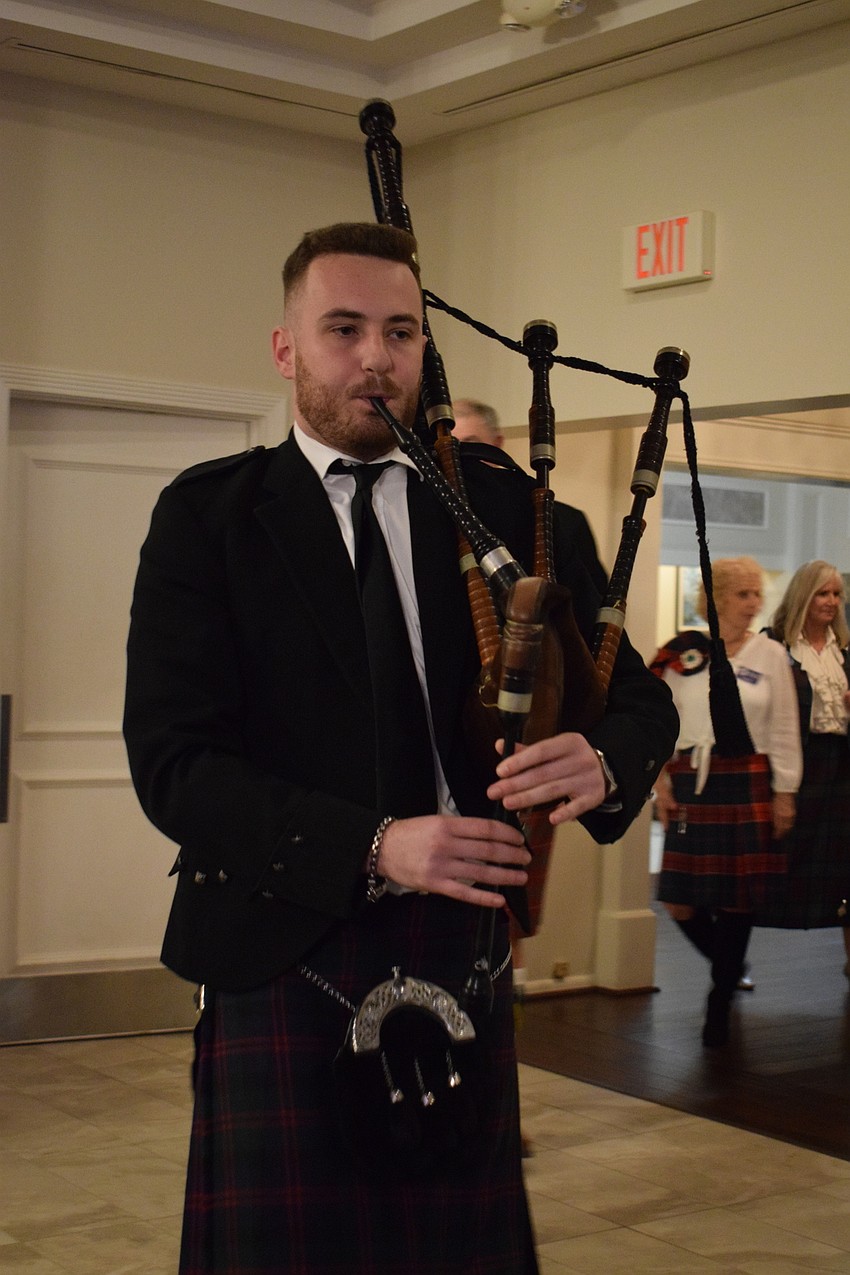 Sarasota's Lewis Ferrier plays bagpipes during the marching in of officers and trustees.