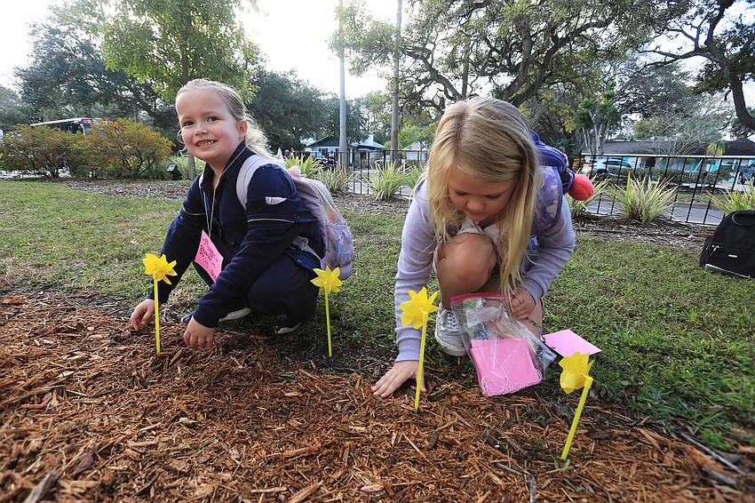 Maggie Thomas and Haven Leach plant their pinwheels together.