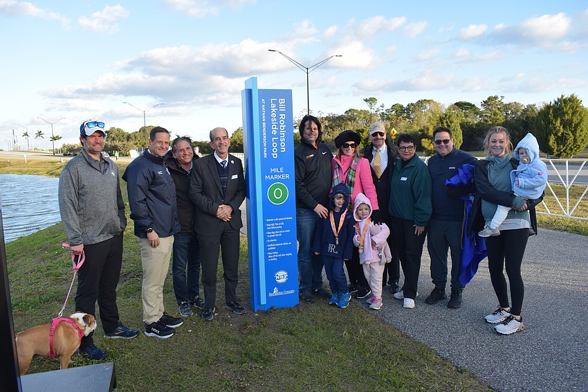 A group of friends and family gather next to one of five mile markers dedicated Jan. 29 to former SANCA Board Chair Bill Robinson, who died in 2020 of leukemia.