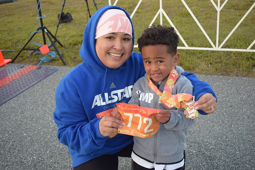 Tiffany Alston and 3-year-old Kevin Alston of Parrish show off Kevin's medal he won in the Kids Dash.