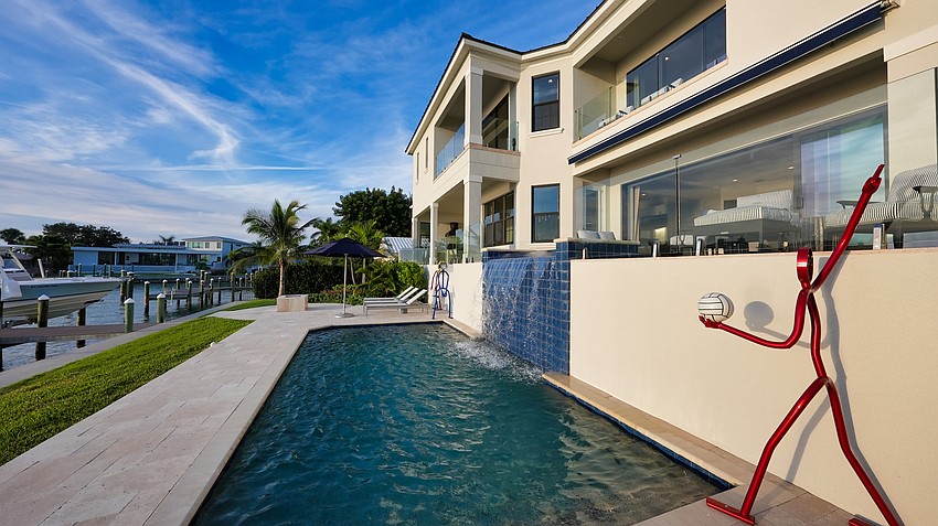 There is a water feature alongside the pool.